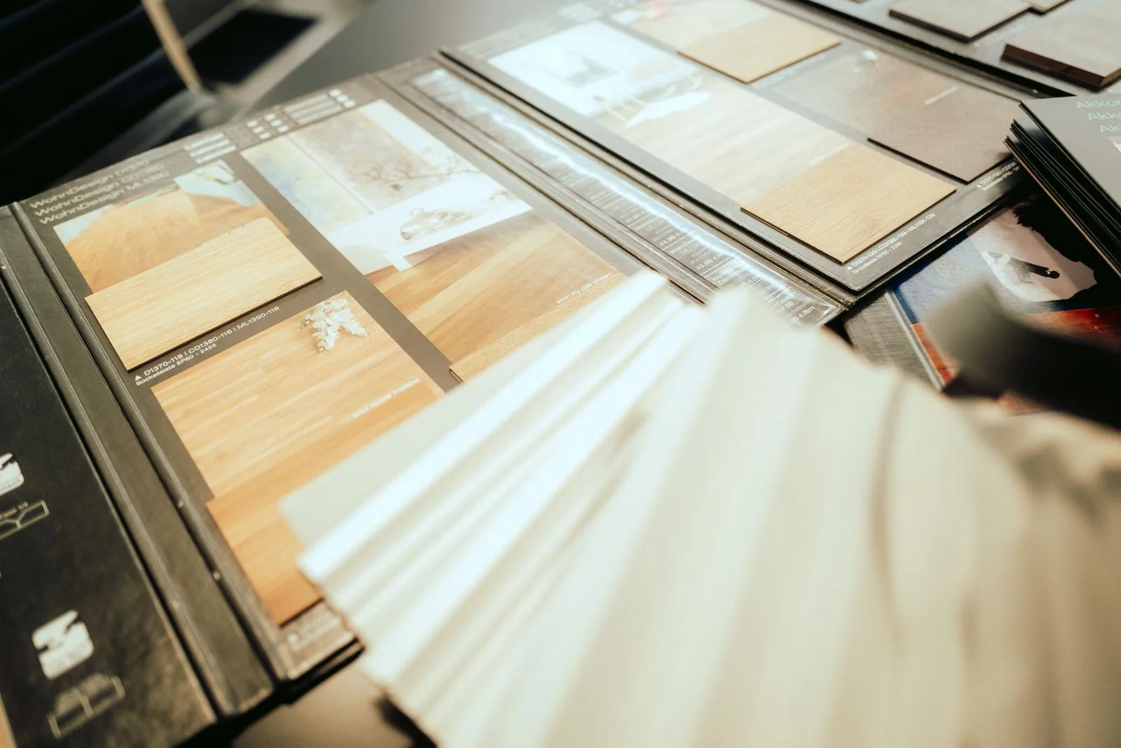 Musterbücher mit Vinyl- und Holzdekoren, aufgeschlagen auf dem Beratungstisch